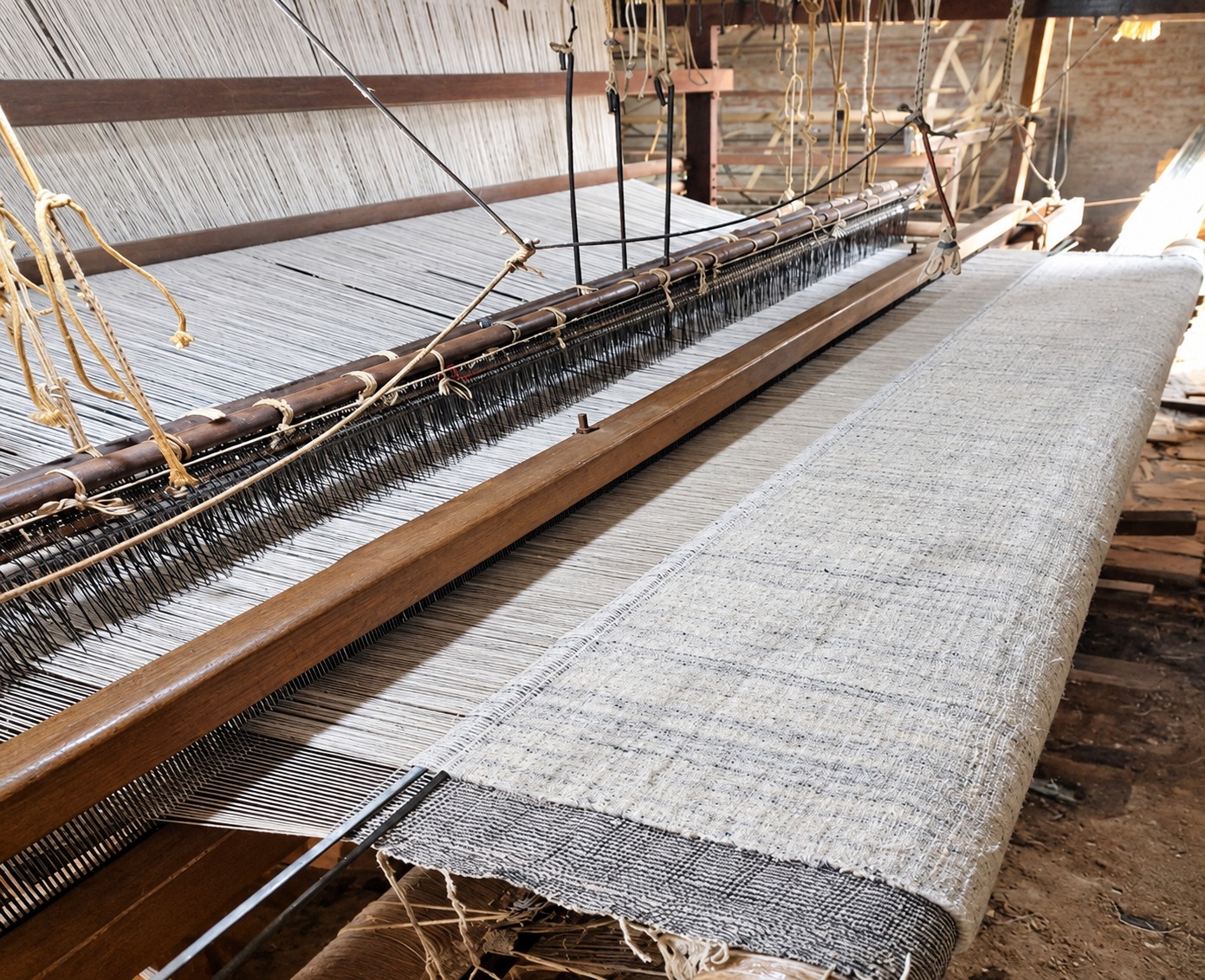 Yarn and a woven rug on a wooden loom